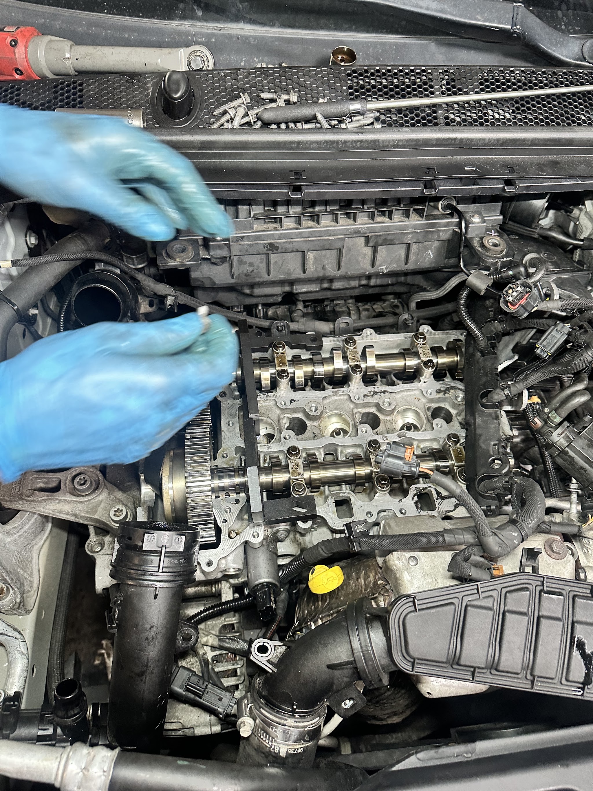 Monteur met blauwe handschoenen werkt aan een geopende motor